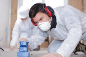 featured image showing a man sanding wood while wearing ppe