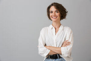 Featured image showing a young happy woman in a business casual outfit smiling.