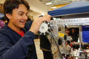 Featured image showing an elementary student working on building a robot.
