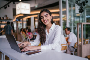 Featured image showing a working on her laptop in a trendy coworking space