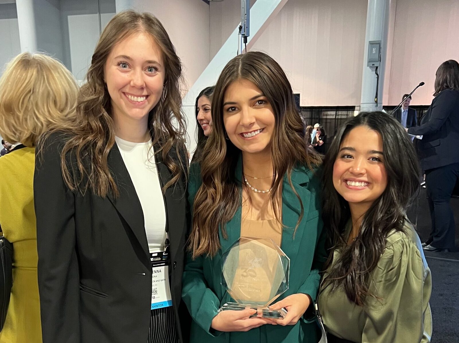Featured image showing Alexis from ZLine posing with Colleagues at an awards ceremony while holding an award and smiling at the camera.